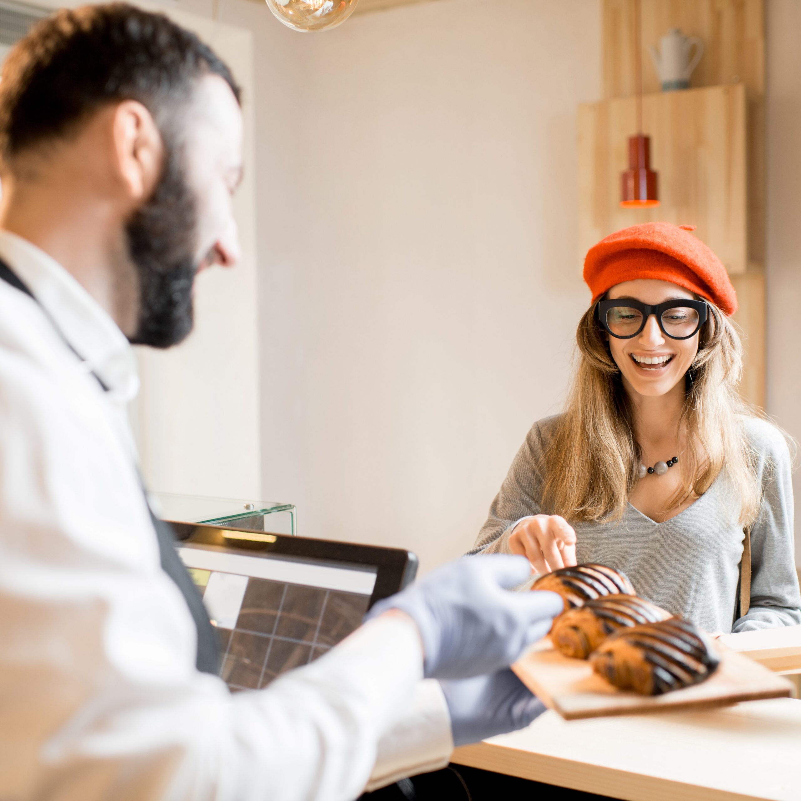 Young woman choosing a croissant in the bakery store